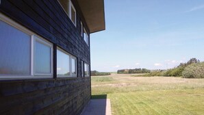 Ein modernes Gebäude mit großen Fenstern mit Blick auf eine grüne Wiese.