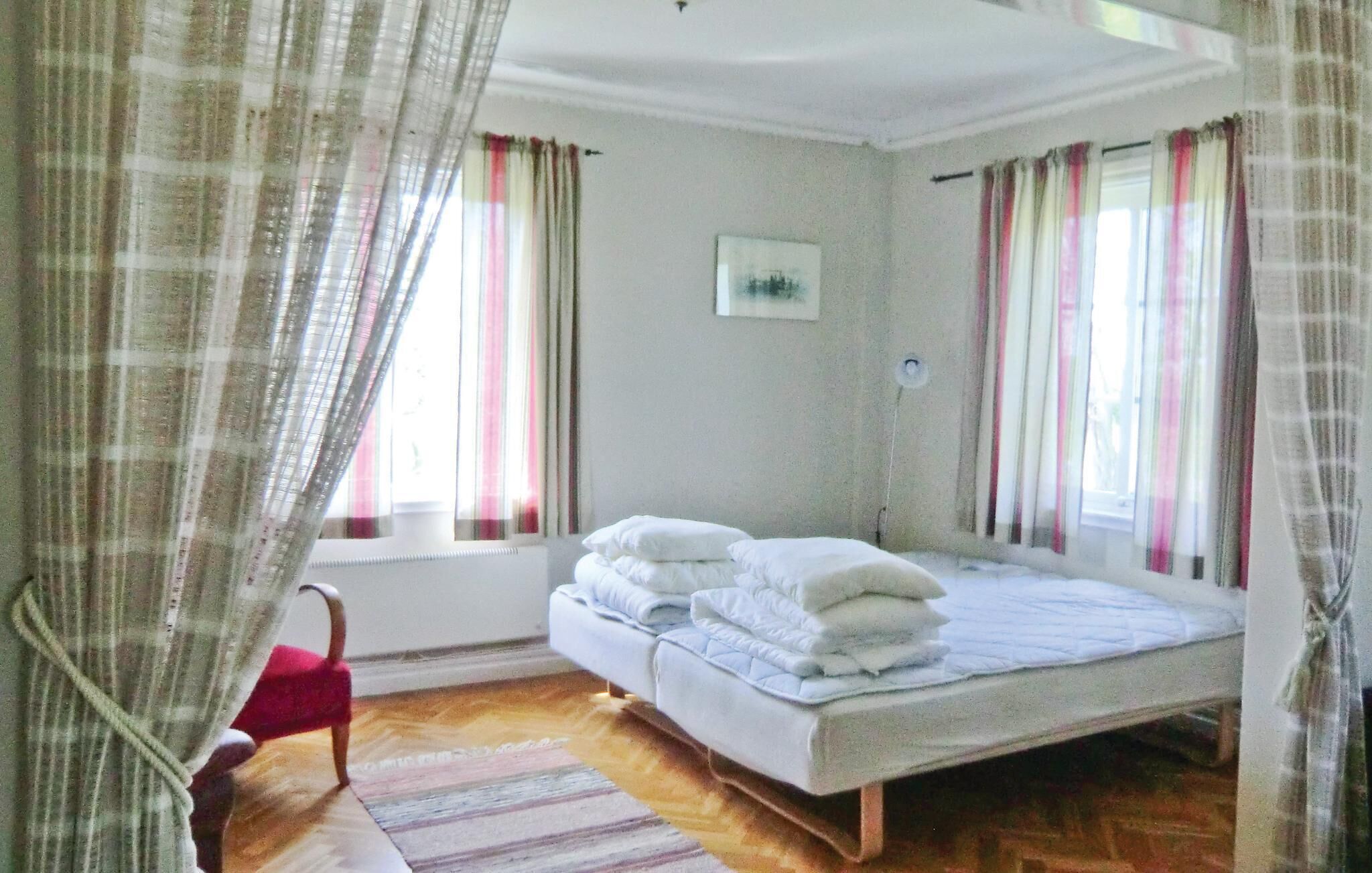 Une chambre à coucher avec un lit, une chaise et des rideaux.