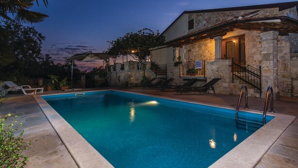 A swimming pool with lounge chairs and a stone building with a staircase. - Amazing home in Puzari (Puzari)