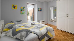 A bedroom with a bed, a nightstand, a wardrobe, and artwork on the walls. - Amazing home in Puzari (Puzari)