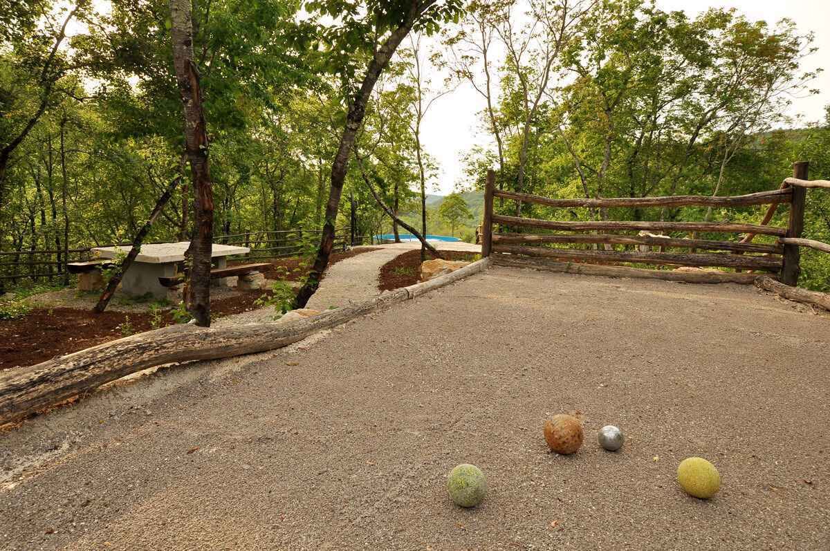 A gravel path with a wooden fence and trees in the background.