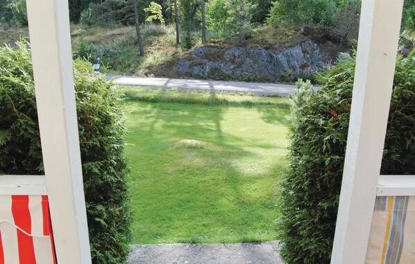 A view through a gate into a grassy area with a road in the background. - Cozy home in Dalskog with kitchen (Dalskog)