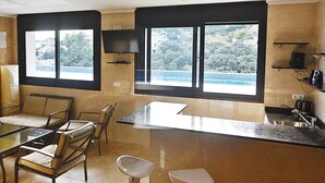 Una cocina moderna con comedor, ventanas amplias con vistas y electrodomésticos integrados.