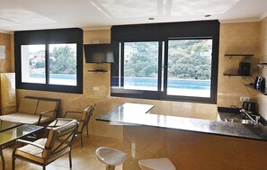 A modern kitchen with a dining area, large windows with a view, and built-in appliances.
