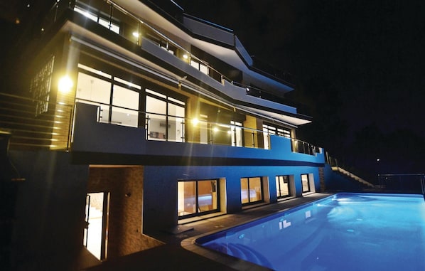 A multi-story building with a swimming pool at the front.