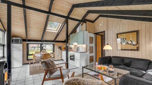 Ein gemütliches Wohnzimmer mit Kamin, ein Essbereich mit Ausblick und eine Küche mit modernen Geräten.
