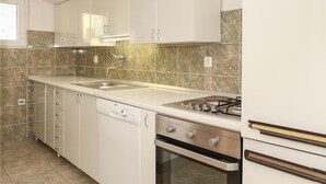 A kitchen with white cabinets, a stainless steel stove, and a dishwasher. - 3 bedroom beautiful apartment in Omis (Omis)