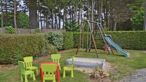 A playground with a swing set and slide, surrounded by green chairs and a sandbox. - 6 bedroom stunning home in Pénestin (Pénestin)