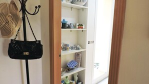 Une cuisine avec des meubles blancs, un sac à main noir et divers ustensiles de cuisine.