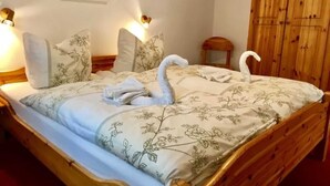 Una cama bien hecha con ropa de cama y toallas dispuestas en forma de cisne.
