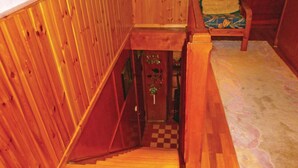 Eine Holztreppe führt zu einer Tür mit einem Schachbrettmuster auf dem Boden.