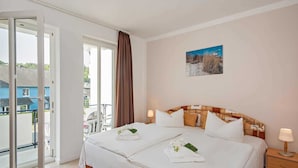 A double bed with white bedding, a brown headboard, and a painting on the wall. - Blaue Welle Whg. 11 Marius // - BW 11 (Heringsdorf)