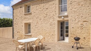 A stone building with a patio area featuring a table and chairs, a grill, and windows. - Nice home in Vaudoy-en-Brie with WiFi (Vaudoy-en-Brie)