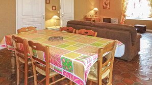 A dining area with a table covered in a colorful tablecloth, surrounded by wooden chairs. - Nice home in Vaudoy-en-Brie with WiFi (Vaudoy-en-Brie)
