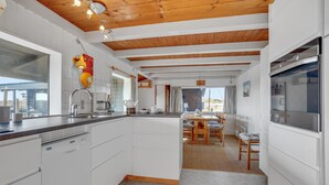 A modern kitchen with white cabinetry, a wooden ceiling, and a central island. - Stunning home in Fanø with WiFi (Fanø)