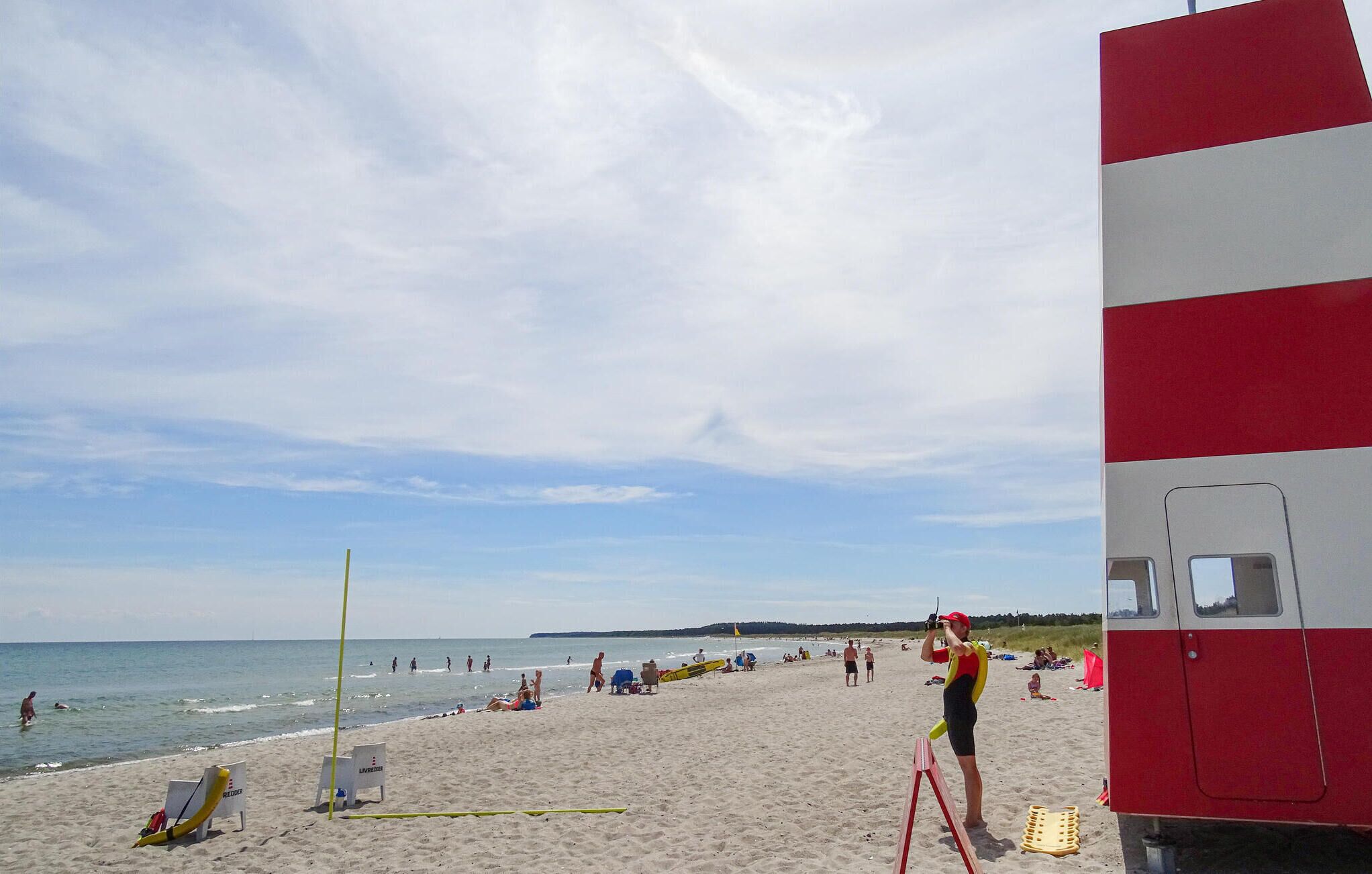 A beach with a lifeguard tower, beach chairs, and umbrellas.