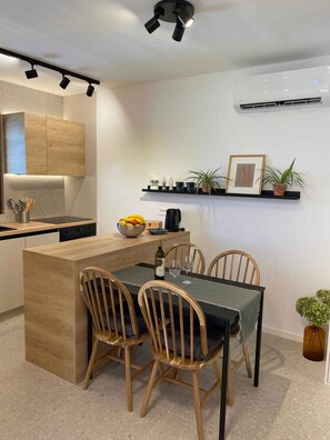 A modern kitchen with a central island, wooden chairs, and a dining table. - Holiday apartment with air conditioning and internet (Medulin)