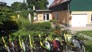 Une rangée de vélos jaunes est stationnée dans un espace prévu à cet effet, avec un bâtiment en arrière-plan.