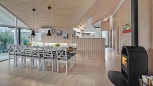 Eine moderne Küche mit Holzwänden, einer zentralen Kochinsel und einem Holzofen.
