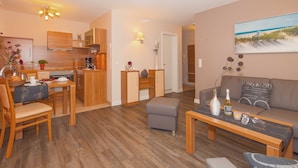 Un salon moderne comprenant un canapé, une table basse et un coin repas avec une table et des chaises.