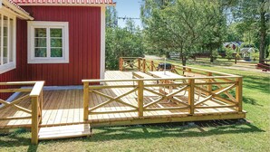 En röd byggnad med en träveranda och ett picknickbord.