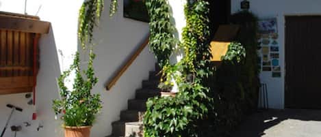 A building with a staircase, a wooden door, and a number '71' on the wall.