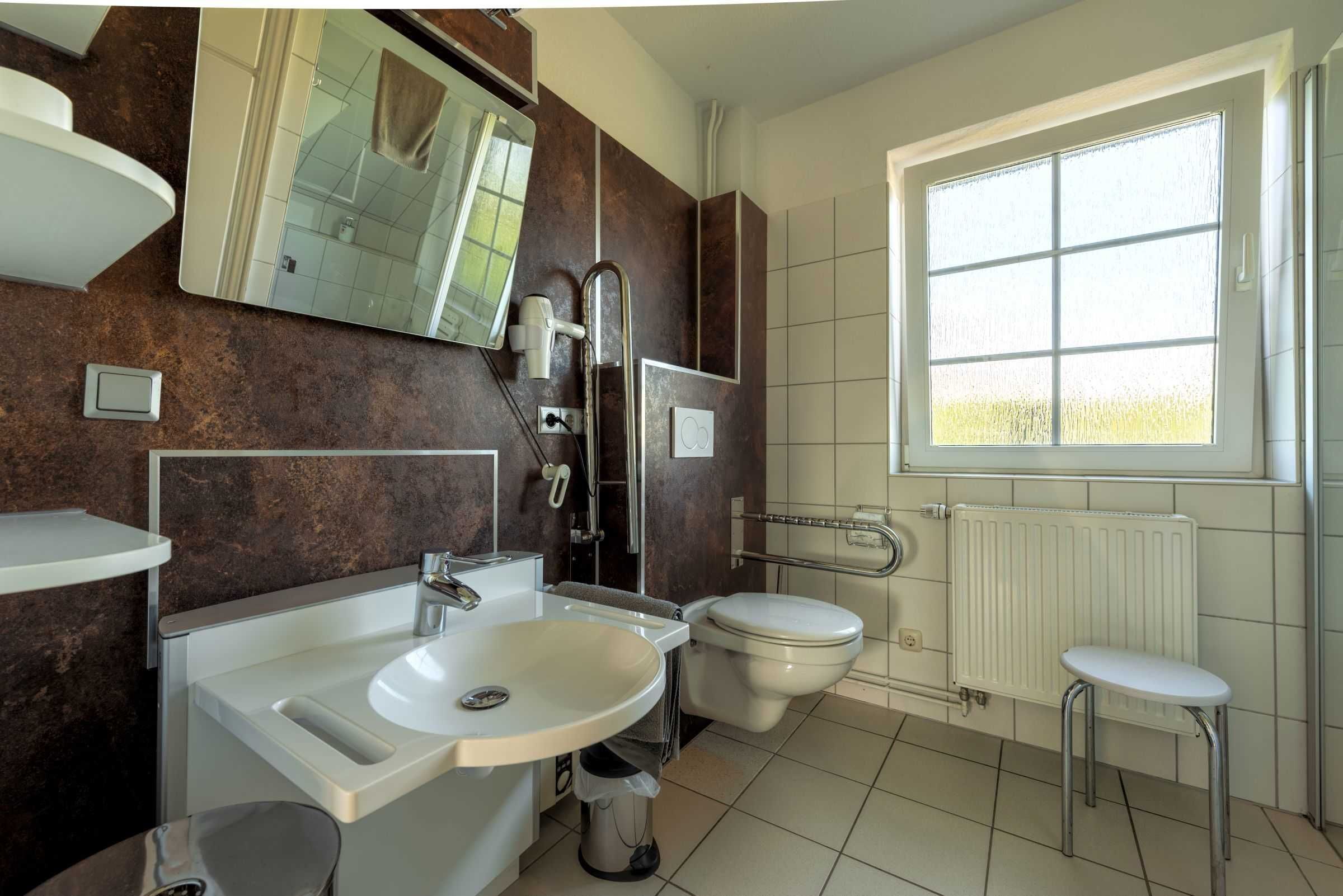Un bagno moderno con lavandino, WC e doccia.