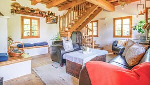A cozy living room with a wooden staircase, leather sofas, and a rustic decor. - schönes Ferienhaus Reinersdorf (Reinersdorf)