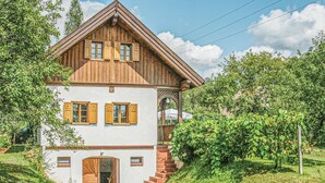 A two-story wooden house with a balcony and a staircase leading to the entrance. - schönes Ferienhaus Reinersdorf (Reinersdorf)