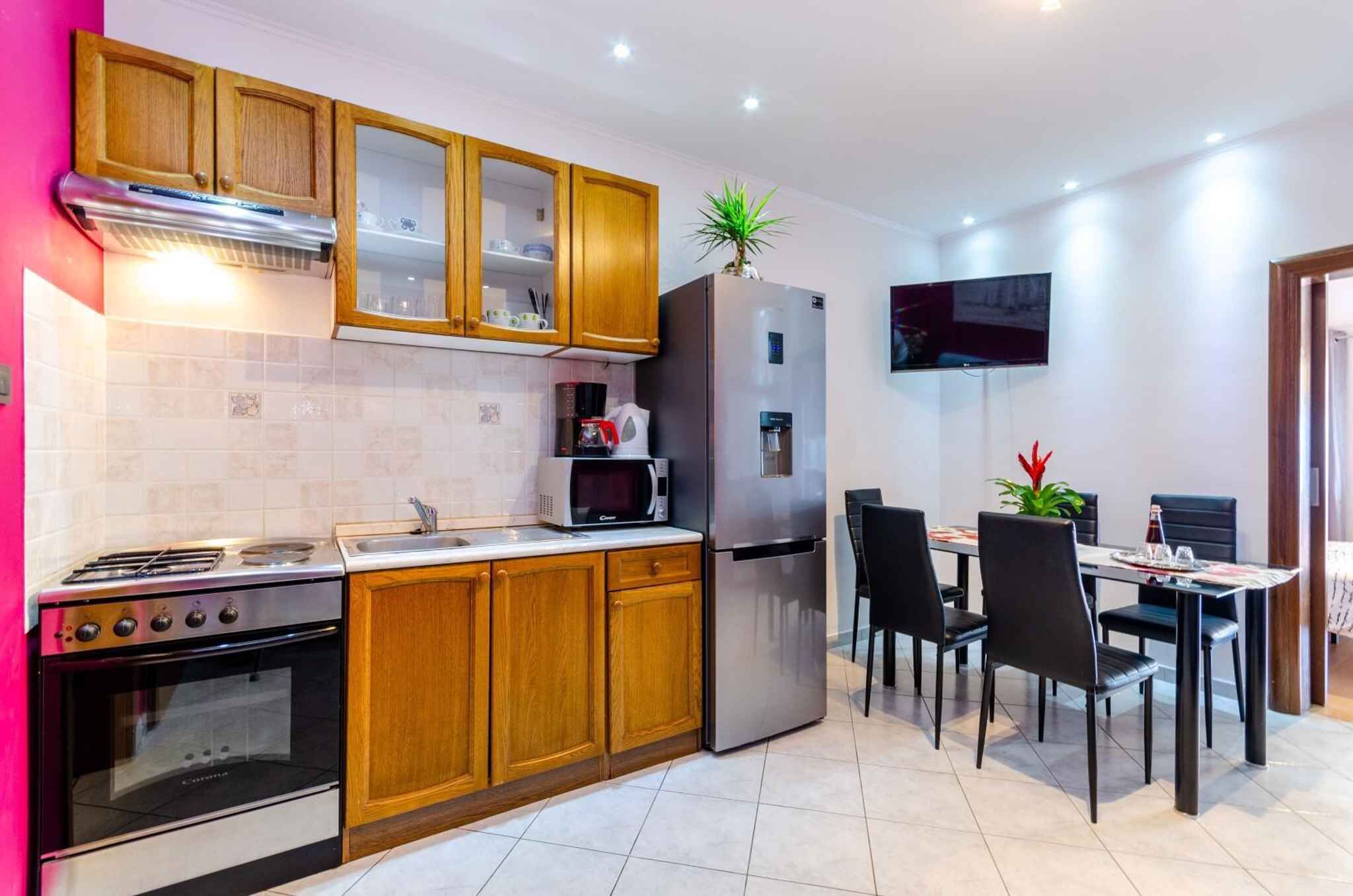 A modern kitchen with wooden cabinets, a stainless steel stove, a microwave, and a refrigerator.