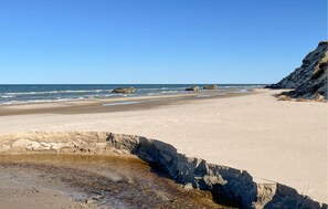 A beach with clear skies, rocky outcrops, and calm waves. - Amazing home in ålbæk with WiFi (Ålbæk)