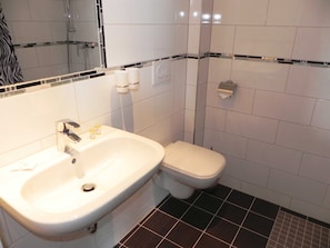 Ein Badezimmer mit Waschbecken, Toilette und Spiegel.