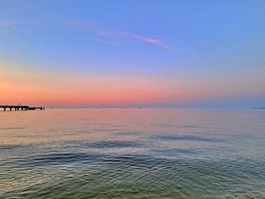 Un mare calmo con un molo che si protende nell'acqua.