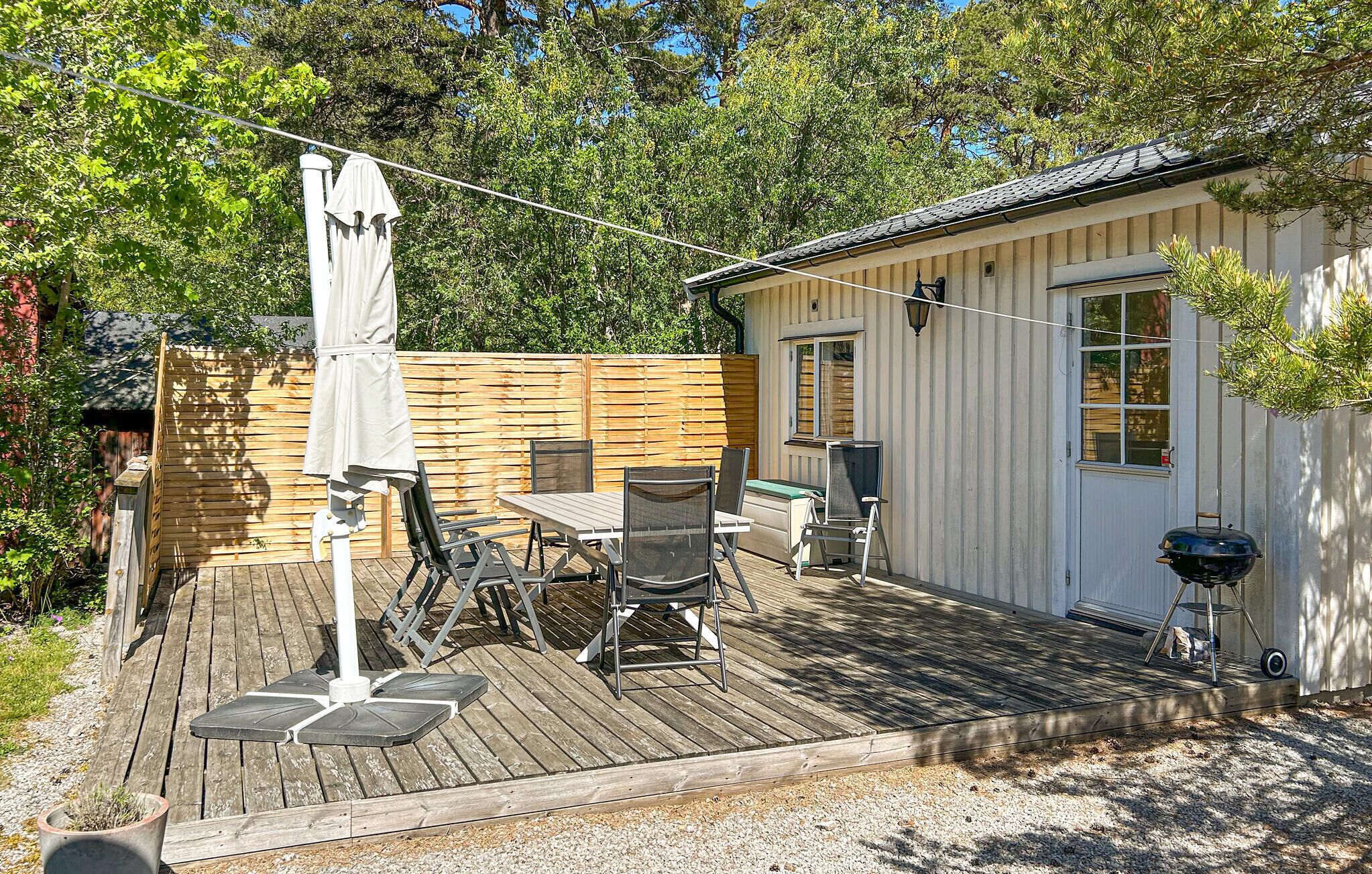 A wooden deck with outdoor furniture, a grill, and a small shed.