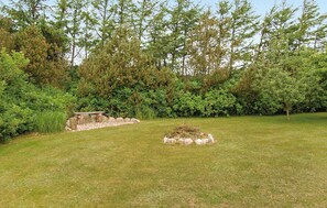 Sit on a serene stone bench amidst lush foliage and dense trees.