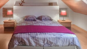 Ein Schlafzimmer mit einem Bett, zwei Nachttischen und zwei Lampen.