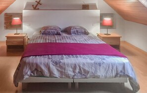 A bedroom with a bed, two nightstands, and two lamps. - Stunning home in Plouhinec with kitchen (Plouhinec)