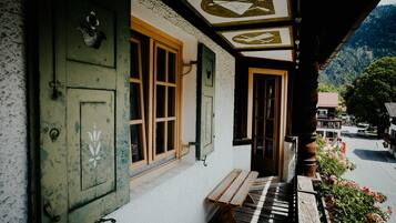 A building with a wooden bench outside, a door, and a window.