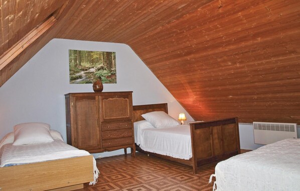 A bedroom with two beds, a wooden dresser, and a painting on the wall. - 2 bedroom stunning home in Kerbors (Kerbors)