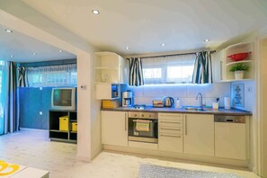 A compact kitchen with a built-in oven, a coffee maker, and a sink. - Holiday apartment only 250 m from the sandy beach on the Gold Coast (Siófok)