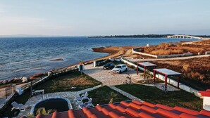 Una propiedad costera con piscina, mobiliario exterior y vista al mar y un puente.