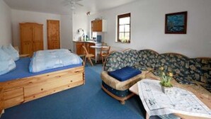 A room with two beds, a desk, a chair, a sofa, and a ceiling fan. - Apartment 1 - Apartments family Moll (Benz)