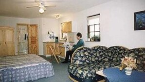 A room with a bed, a sofa, a dining table, and a kitchen area. - Apartment 1 - Apartments family Moll (Benz)
