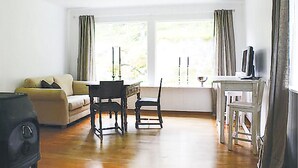 A living room with a sofa, a dining table with chairs, and a TV stand. - Pet friendly home in Eidfjord with WiFi (Eidfjord)