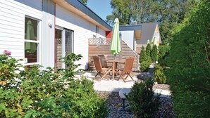 A house with a patio area featuring a table and chairs, surrounded by greenery and a small garden. - Pet friendly home in Süssau/Ostsee (Süssau/Ostsee)