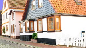 A row of traditional European houses with distinct roof tiles and wooden window frames. - Apartment East - Family Jansen - Home sweet home (Maasholm)