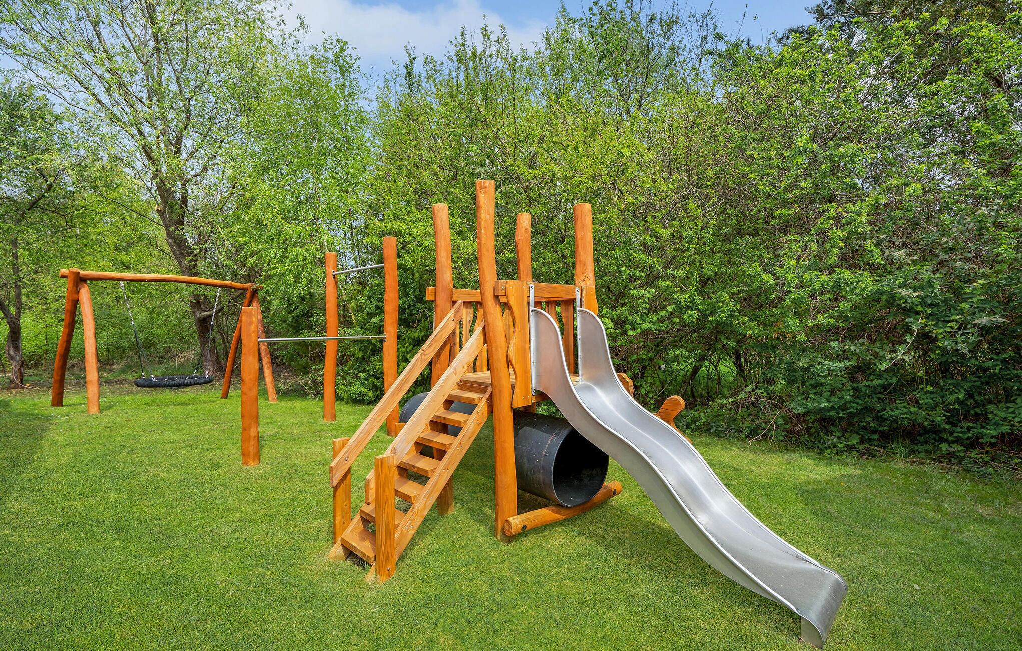 A playground with a slide, swing set, and climbing structure.