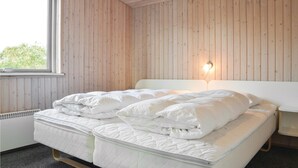 A room with a bed, wooden walls, a window, and a wall-mounted light. - Nice home in Ringkøbing with sauna (Ringkøbing)