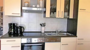 A compact kitchen with a coffee maker, a dish rack, and a set of cabinets. - Nice apartment in Boiensdorf with WiFi (Boiensdorf)