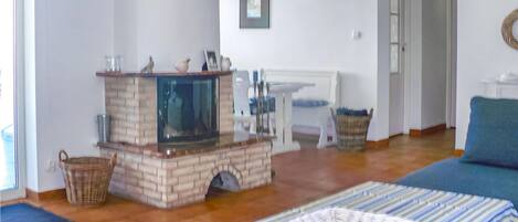 Um quarto com lareira, mesa de jantar e sofá.